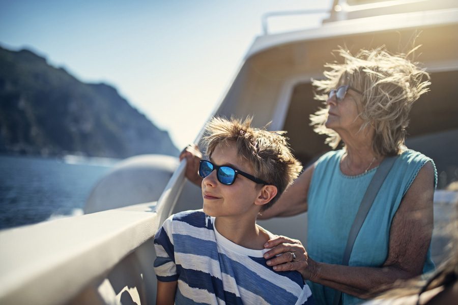 Senior woman with grandson travelling by boat admiring the view